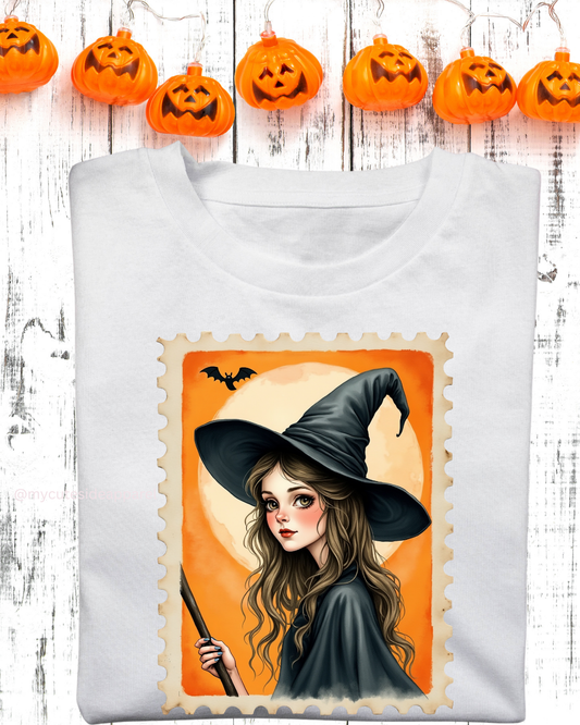 White sweatshirt with a Halloween-themed design of a witch on an orange background, with pumpkins in the background.